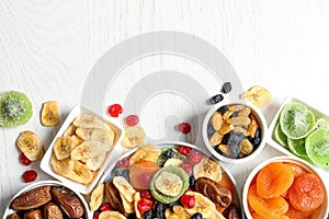 Bowls of different dried fruits on wooden background, space for text. Healthy lifestyle