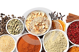 Bowls with different spices on white background, top view