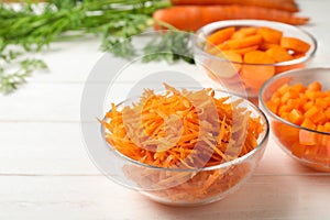 Bowls of differently cut carrots on white