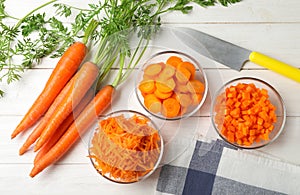 Bowls of differently cut carrots on white background