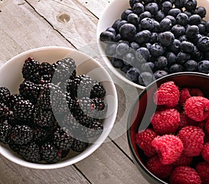 Bowls of fresh fruit on wooden background