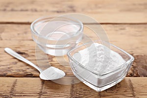 Bowls of fructose syrup and powder on wooden table