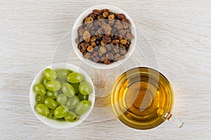 Bowls with grape and raisins, cup with grape juice