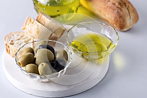Bowls with Green and Black Olive Olive Oil on White Tray Artisan Bread Mediterranean Food Blue Background Horizontal