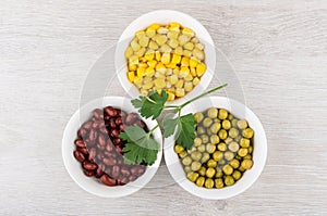 Bowls with green peas, beans, sweet corn and parsley