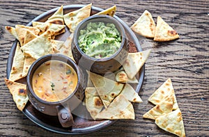Bowls of guacamole and queso with tortilla chips