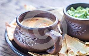 Bowls of guacamole and queso with tortilla chips photo