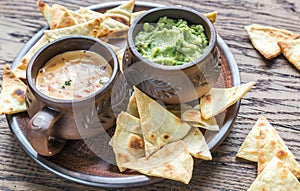 Bowls of guacamole and queso with tortilla chips photo