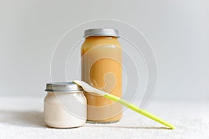 Bowls of pureed food with spoon for baby over blurred background