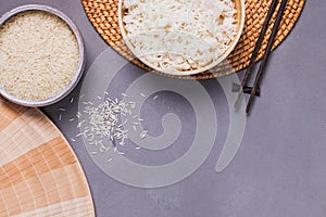 Bowls with raw and cooked white long grain rice