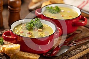 Bowls of split pea soup with ham and carrots garnished with parsley