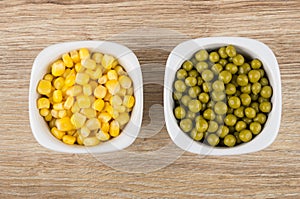 Bowls with sweet corn and green peas on table