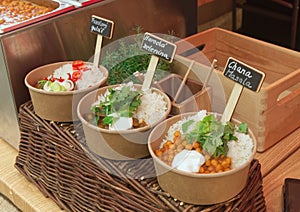 Bowls with to go meals at farmers market.