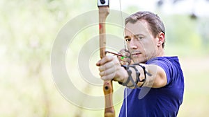 Bowman aiming arrow at target photo