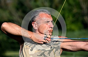 Bowman aiming with bow and arrow photo