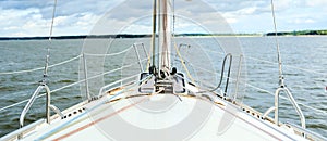 Bows of a yacht sailing offshore in summer in a first person point of view on a calm ocean