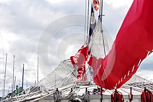 Bowsprit and gathered red sail of the sailing ship.