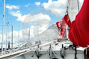 Bowsprit and gathered red sail of the sailing ship.