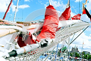 Bowsprit and gathered red sail of the sailing ship.