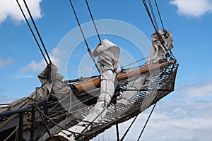 Bowsprit and jib boom with reefed sails on the bow of a historic