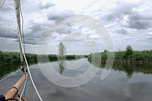 Bowsprit of a sailing yacht on a tranquil river