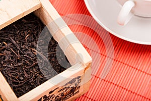 Box with black tea on red mat
