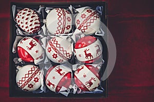 Box with Christmas Decorations on Dark Red Vintage Background