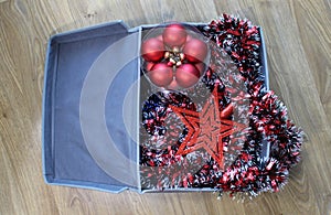 A box with Christmas decorations stands on the floor