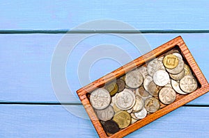 box with coins of countries of the world on a blue wooden background. money.a Palestinian coin, a Soviet coin, an Israeli