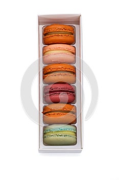 Box with colorful macaroons top view on white background isolated