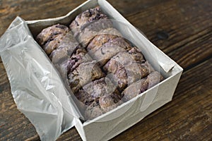 A box of delicious ube flavored Hopia or Bakpia placed on a wooden table. A bean-filled moon cake-like pastry