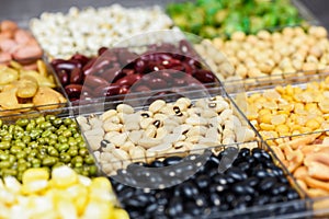Box of different whole grains beans and legumes seeds lentils and nuts colorful snack background top view - Collage various beans