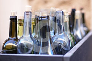 Box with empty wine bottles in defocus, concept of drunkenness