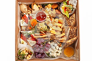 A box of food, cheese, breads, fish, shrimp. Food delivery for the company, romantic, office dinner at home. Beautiful composition