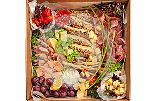 A box of food, cheese, breads, fish, shrimp. Food delivery for the company, romantic, office dinner at home. Beautiful composition