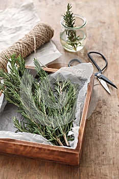 Box with fresh rosemary on wooden table