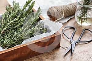 Box with fresh rosemary on wooden table, closeup