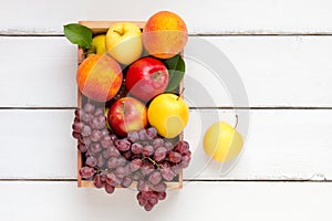 Box of fruits with apples, peaches and grape. Top view