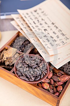 A box full of Chinese herbal medicine and a plate of traditional Chinese medicine xiangfuzi and prescriptions on it