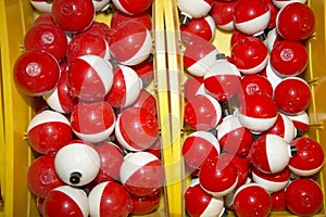 Box full of red and white plastic bobbers