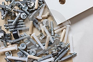 Box with furniture assembly parts, bolts and screws close up