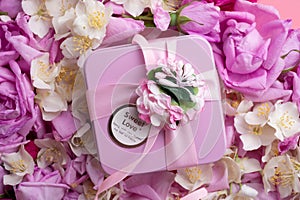 Box with gift  around roses  and  jasmine background. romantic and beauty concept