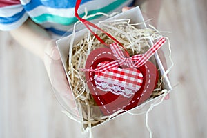 Box with a gift valentine heart in a child& x27;s hand on Valentine& x27;s