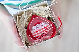 Box with a gift valentine heart in a child& x27;s hand on Valentine& x27;s