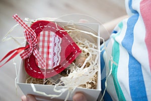 Box with a gift valentine heart in a child& x27;s hand on Valentine& x27;s