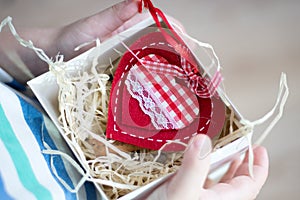 Box with a gift valentine heart in a child& x27;s hand on Valentine& x27;s