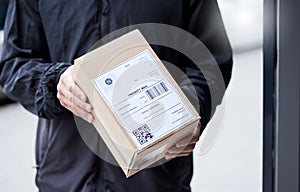 Box, hands and courier at entrance for a delivery, ecommerce work or cargo shipping. Closeup, logistics and man or