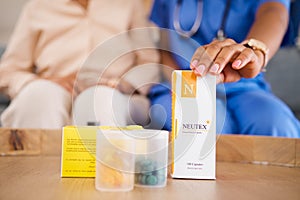 Box, hands and medicine with doctor, patient and table in home for wellness, healthcare and advice. Medic, pills and