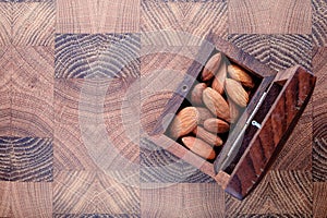 box is mahogany with nuts snack salted almonds wooden cooking Board top view