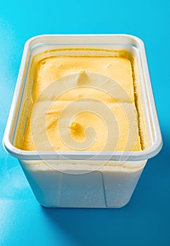 Box of mango flavor ice cream on blue background vertical composition